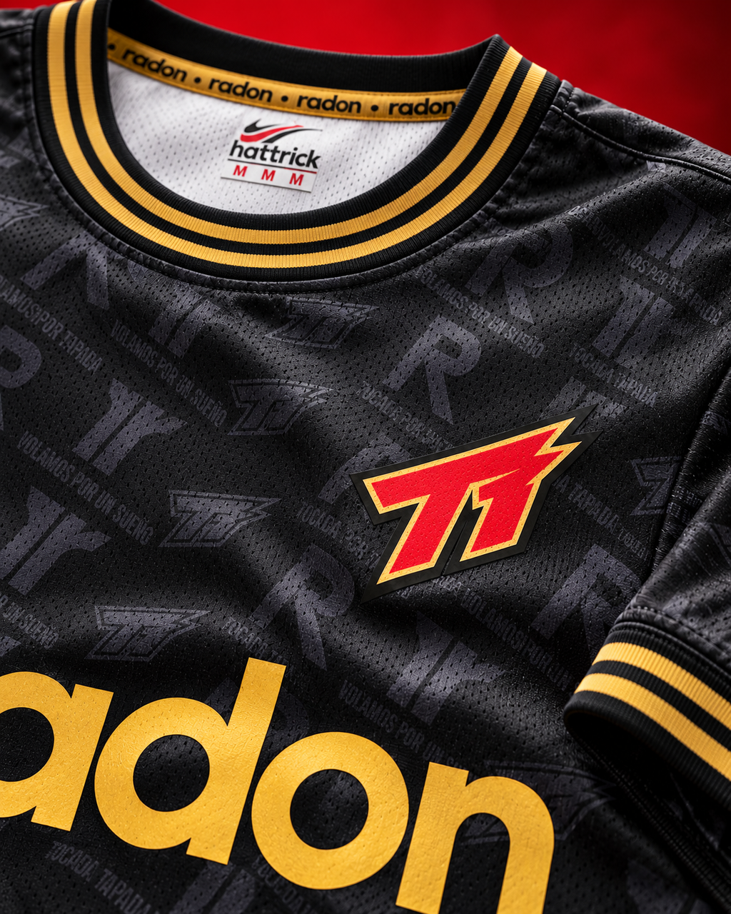 Detalle del escudo Tocada Tapada y cuello dorado de la camiseta 4° Edición